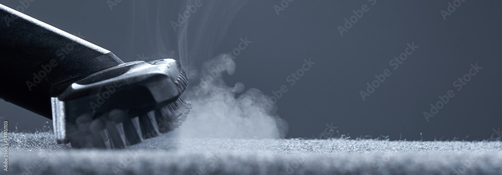 Home cleaning. Steam carpet cleaning on a grey background. Photo from copy space.