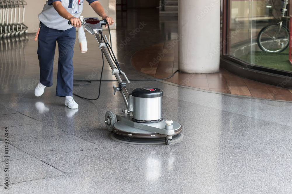 Woman cleaning the floor with polishing machine