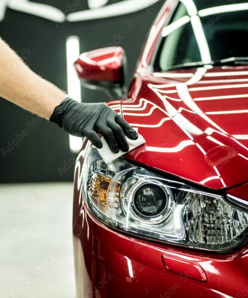 Car service worker applying nano coating on a car detail.