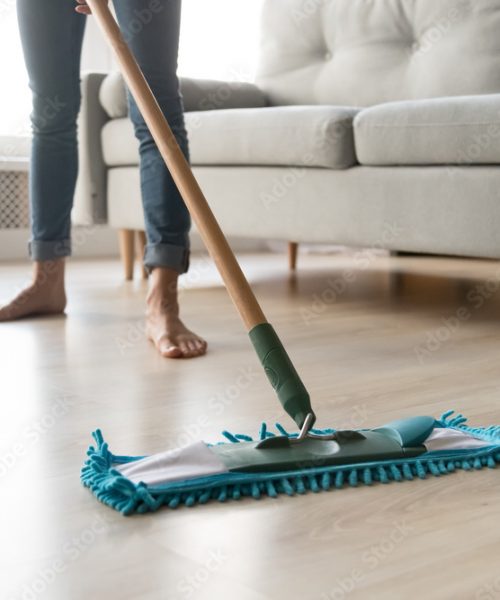 Woman housewife holding mop cleaning floor at home, close up